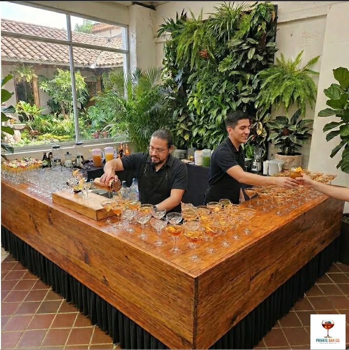 Barra Premium Signature de Private Bar Co. en salón elegante con muro verde